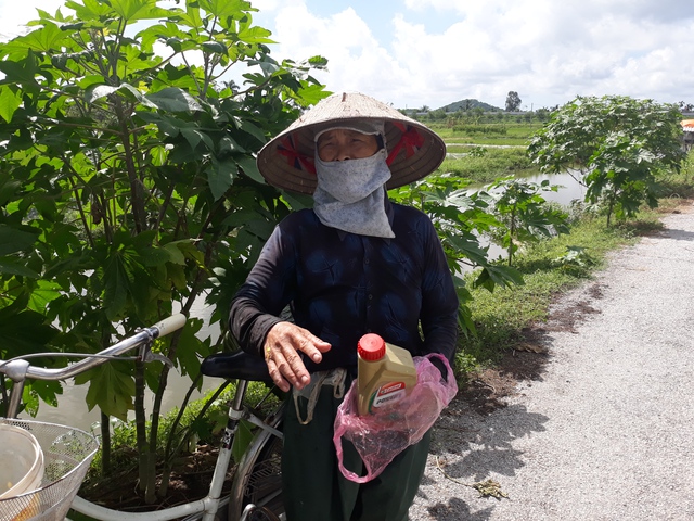 
Bà Thanh mang chai dầu luyn xuống đổ xung quanh bờ ruộng nhà bà để ngăn chuột.
