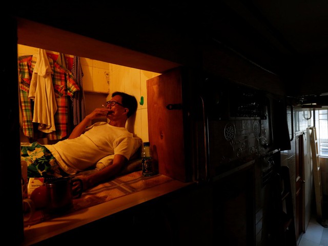 
Simon Wong, 65 tuổi, sống trong “căn nhà” chỉ đủ rộng để treo vài cái áo, một hai cái quần.
