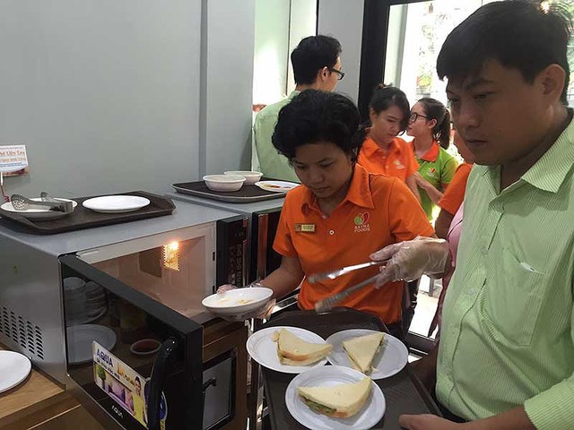 Các món ăn vặt rất được người Việt ưa chuộng. Trong ảnh: Khách hàng đang tự tay hâm nóng thức ăn bằng lò vi sóng có sẵn ở  cửa hàng tiện lợi. Ảnh: TÚ UYÊN