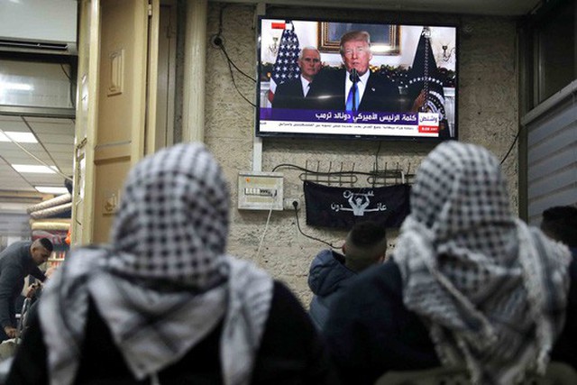 
Người Palestine ở Thành Cổ tại Jerusalem xem truyền hình đưa tin về bài phát biểu của Tổng thống Mỹ Donald Trump hôm 6-12 Ảnh: REUTERS
