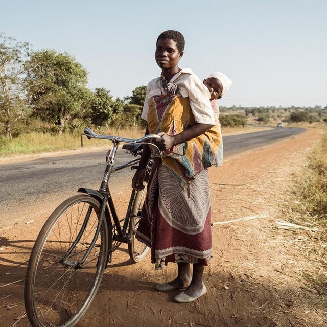 
Nhiếp ảnh gia Natalia Horinkova, người chụp bức ảnh bà mẹ ở Malawi này đã nói: Người mẹ này là một trong số ít những người phụ nữ ở đây biết đi và sở hữu một chiếc xe đạp. Và một khi đã biết đi xe rồi thì họ có thể đèo con họ rong ruổi khắp nơi.
