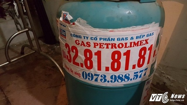 Tờ thông tin có số điện thoại cửa hàng được nhân viên gas dán đè lên các số cũ ở các bình gas và trước cửa nhà người dân.