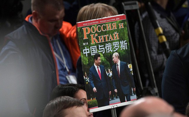 Phóng viên mang theo tấm poster tổng thống Putin và chủ tịch Trung Quốc Tập Cận Bình