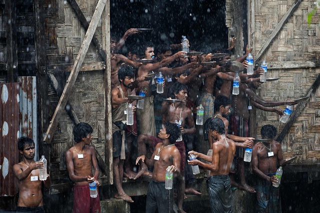 
Những người di cư Bangladesh và Rohingya tích nước mưa tại một nơi trú ẩn tạm thời ở Myanmar.
