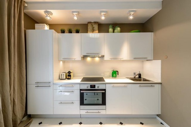 Một hệ thống tủ kệ khép kín nơi bếp ăn làm tăng không gian lưu trữ. Một vài chậu cây cảnh cũng góp mặt nhằm đưa sức sống của thiên nhiên vào trong nhà bếp.