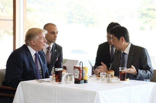 Hai nhà lãnh đạo Mỹ (trái) và Nhật thưởng thức bánh mì kẹp của nhà hàng Munch’s Burger Shack. Ảnh: EVENING STANDARD
