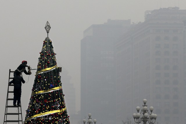 
Một người thợ đang tu sửa cây thông Noel khổng lồ tại thành phố Bắc Kinh giữa bầu không khí không được trong lành cho lắm.
