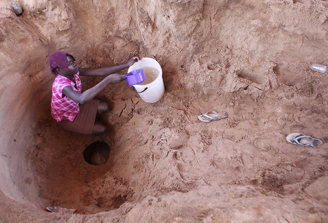
Người phụ nữ này cố vét những ca nước hiếm hoi từ con sông Chemumvuri cạn nước ở Zimbabwe.
