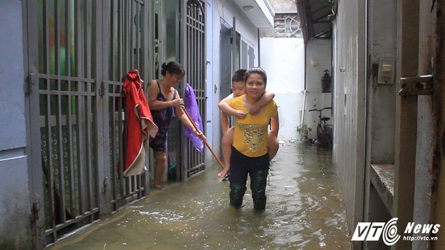 Có những nơi nước ngập qua đầu gối khiến việc di chuyển của người dân gặp nhiều khó khăn.