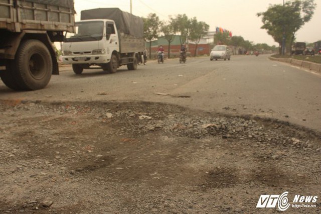 Đường bị bong tróc, tạo hố sâu khiến giao thông qua lại khó khăn.