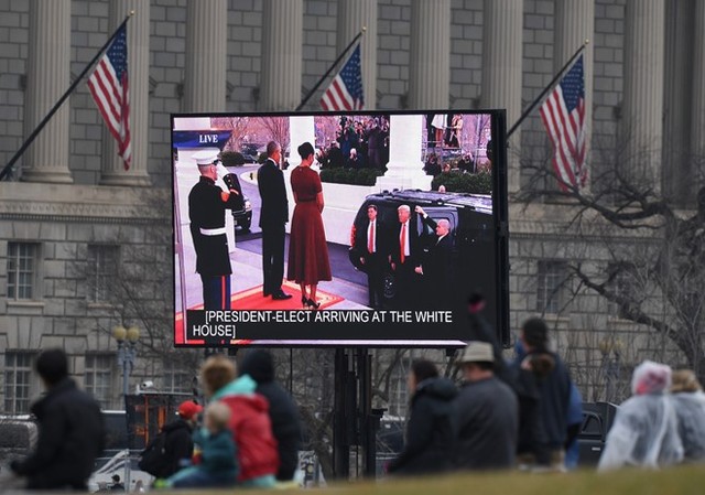 Cảnh gia đình Obama chào đón Trump ở Nhà Trắng được phát trên màn hình lớn đặt ở Quảng trường Quốc gia, nơi hàng trăm ngàn người đang đợi để chứng kiến cảnh ông Trump nhậm chức. Ảnh: AFP.