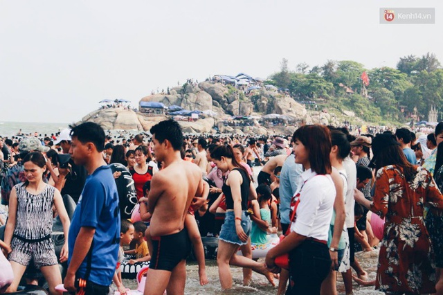 Do số lượng du khách đổ ra bờ biển khá đông nên một số người chỉ có thể đứng trên bờ vui chơi. Ảnh: Thu Hường