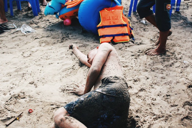 Một nam du khách nằm dài ra bãi cát sau khi tắm biển. Ảnh: Thu Hường