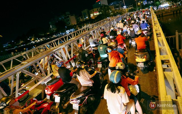 Xe máy ùn ùn nối đuôi nhau qua cầu Trần Khánh Dư.