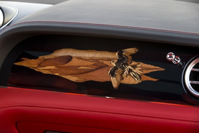 
Phía trước ghế phụ được trang trí bằng hình vẽ chim ưng đang bay trên Sa Mạc trên nền đen của gỗ ốp.
