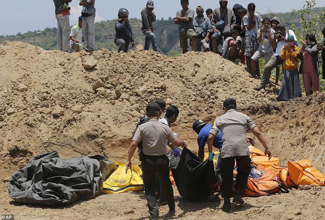 Thảm cảnh máy xúc đào mồ chôn tập thể cho các nạn nhân động đất, sóng thần Indonesia - Ảnh 3.