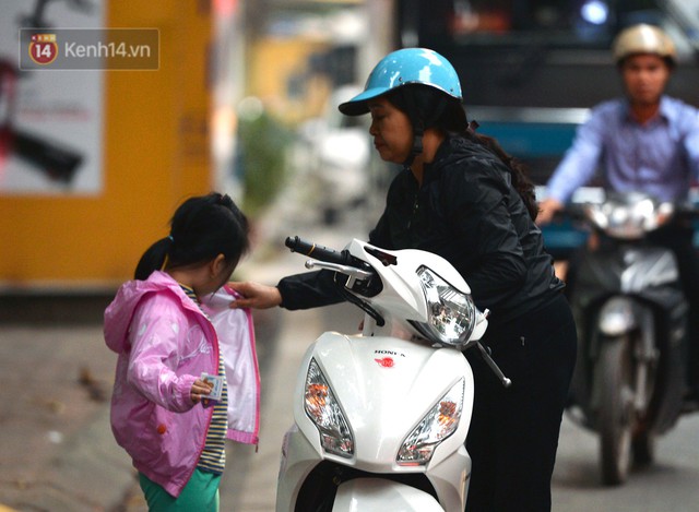 Chùm ảnh: Hà Nội giảm nhiệt độ, người mặc áo khoác dày, người quần đùi áo cộc xuống phố - Ảnh 9.