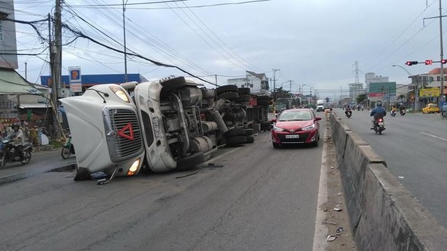 Xe đầu kéo lật ngang trên QL1A,hàng trăm thùng bia đổ tràn ra đường - Ảnh 1.