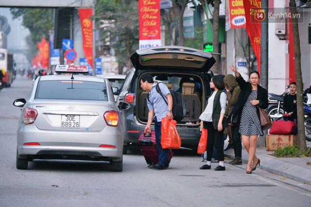 Người dân mang theo hành lí chất trên nóc ô tô, xe máy đổ về Hà Nội và Sài Gòn sau kì nghỉ Tết Nguyên đán kéo dài 1 tuần - Ảnh 4.