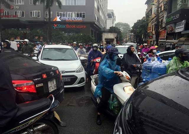  Nhiều tuyến phố Hà Nội tê liệt trong cơn mưa phùn buổi sáng - Ảnh 1.