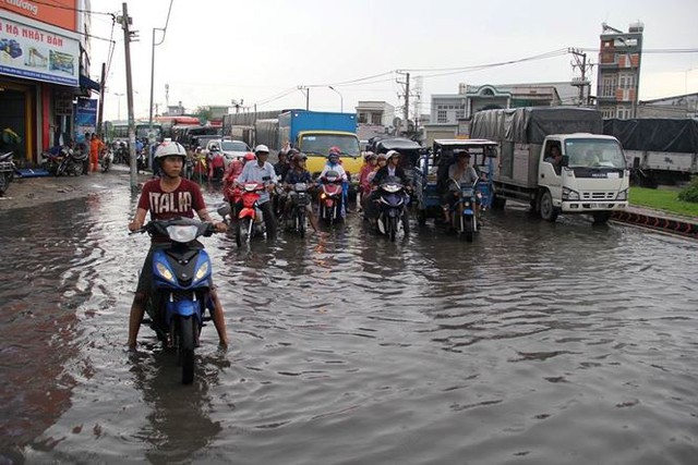 Mưa nhỏ cũng khiến đường Sài Gòn ngập lênh láng  - Ảnh 1.