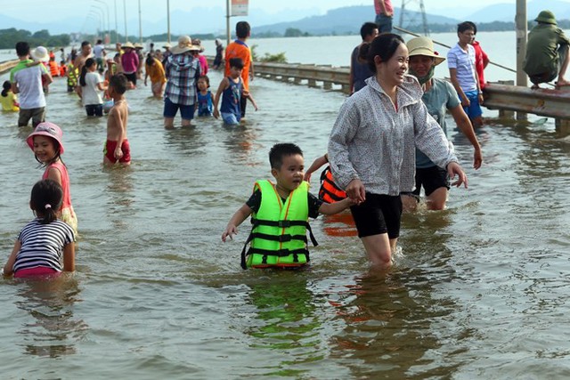 Tỉnh lộ ngập sâu, dân thôn ở Hà Nội nô nức đi bắt cá, cho trẻ ra bơi  - Ảnh 1.