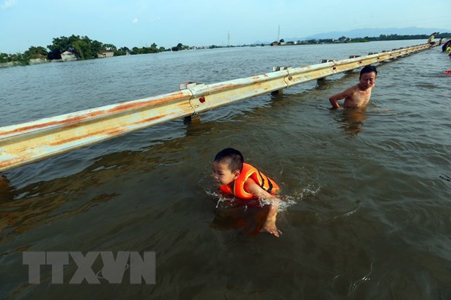 Tỉnh lộ ngập sâu, dân thôn ở Hà Nội nô nức đi bắt cá, cho trẻ ra bơi  - Ảnh 2.