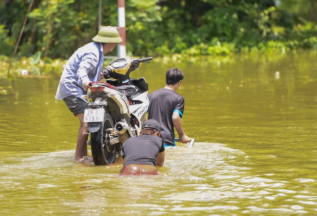 Sau 1 tuần mưa, người Hà Nội dùng thuyền tự chế, bơi trong dòng nước ngập ao bèo về nhà - Ảnh 9.