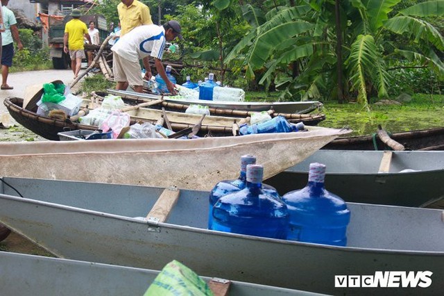 Dân vùng rốn lũ Hà Nội tấp nập chèo thuyền đi lấy nước miễn phí - Ảnh 7.