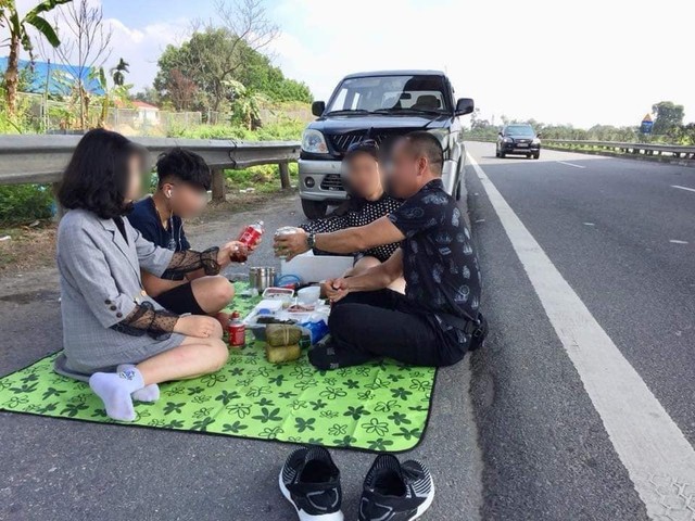 Hình ảnh gây phẫn nộ: Cả gia đình trải bạt, ăn uống trên cao tốc Nội Bài - Lào Cai bất chấp dòng phương tiện chạy rầm rập - Ảnh 1.