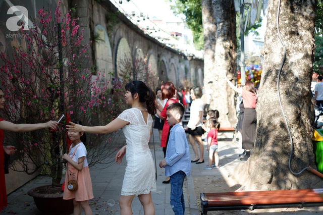 Nắng đẹp, người Hà Nội rủ nhau xuống phố du xuân, xúng xính áo dài chụp ảnh đầu năm mới - Ảnh 11.