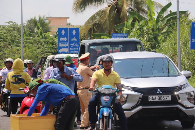 Công an Cần Thơ phát nước suối, khăn lạnh cho người dân lưu thông trên quốc lộ - Ảnh 2.