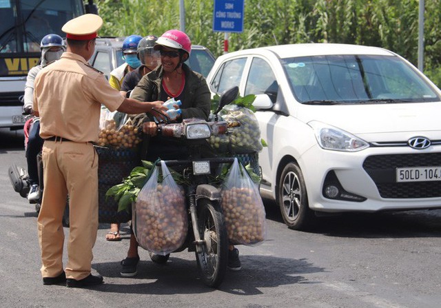 Công an Cần Thơ phát nước suối, khăn lạnh cho người dân lưu thông trên quốc lộ - Ảnh 3.