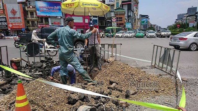 Công nhân đội nắng vá đường ống nước giữa ngã 6 Hà Nội - Ảnh 4.