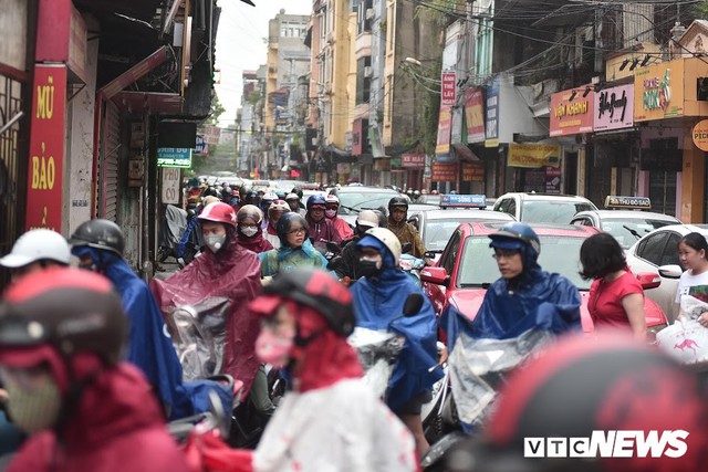 Ảnh: Xe cộ ùn tắc khắp ngả, người dân vất vả mưu sinh dưới trời mưa bão ở Thủ đô - Ảnh 4.