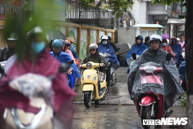 Ảnh: Xe cộ ùn tắc khắp ngả, người dân vất vả mưu sinh dưới trời mưa bão ở Thủ đô - Ảnh 5.