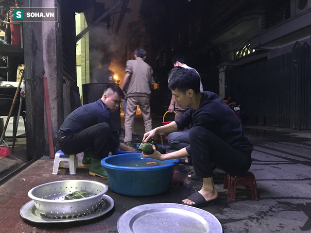  [Ảnh] Độc đáo ở Hà Nội: 10 gia đình luộc chung nồi bánh chưng 100 chiếc trên phố - Ảnh 9.