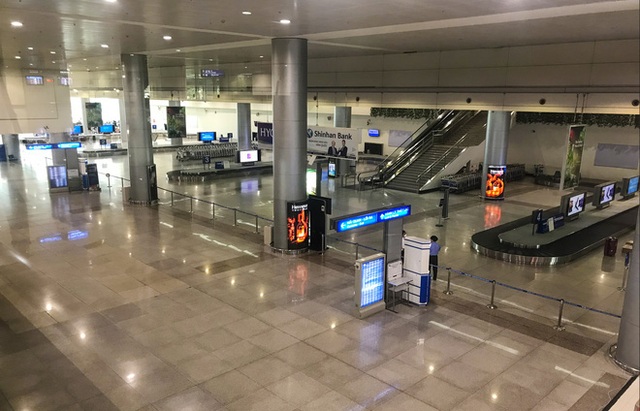  Người dân mặc đồ bảo hộ kín mít ra sân bay, ga quốc tế Tân Sơn Nhất hoang vắng lạ thường - Ảnh 1.