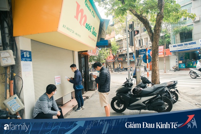 Những hàng ăn nổi tiếng Hà Nội gọi hàng qua khe cửa, chăng dây tạo vùng an toàn, bất cứ ai đặt hàng phải đeo khẩu trang đúng chuẩn - Ảnh 1.