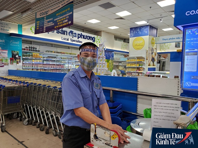 Nhân viên đeo mặt nạ bán hàng, siêu thị hàng hóa ngập kệ trong ngày đầu cách ly xã hội - Ảnh 3.