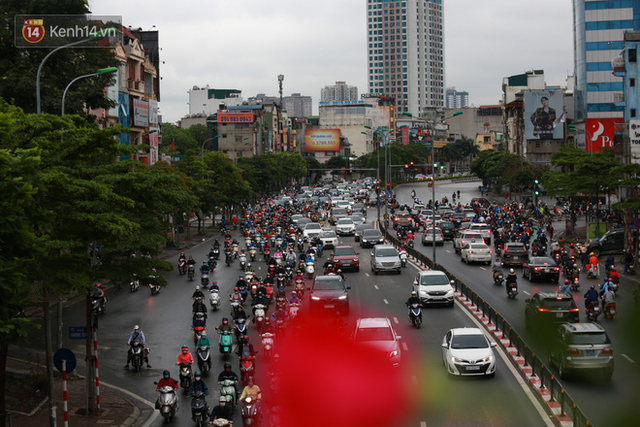 Ảnh: Ngày đầu tiên sau khi nới lỏng cách ly xã hội, đường phố Hà Nội đông đúc kéo dài, người dân chật vật đi làm dưới mưa - Ảnh 5.