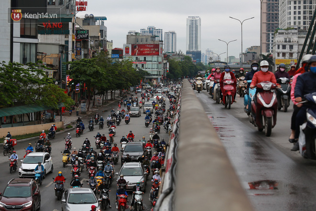 Ảnh: Ngày đầu tiên sau khi nới lỏng cách ly xã hội, đường phố Hà Nội đông đúc kéo dài, người dân chật vật đi làm dưới mưa - Ảnh 7.