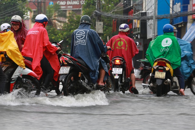  [ẢNH] Nước chảy xiết kéo nhiều xe máy đổ nhào giữa phố Sài Gòn, người dân dắt bộ cho an toàn - Ảnh 2.