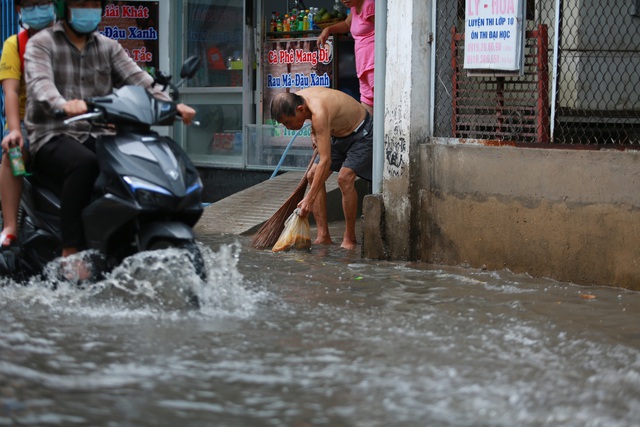  [ẢNH] Nước chảy xiết kéo nhiều xe máy đổ nhào giữa phố Sài Gòn, người dân dắt bộ cho an toàn - Ảnh 12.