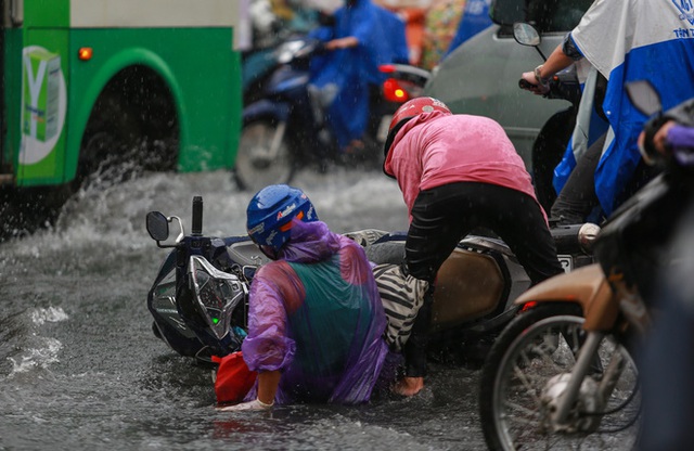  [ẢNH] Nước chảy xiết kéo nhiều xe máy đổ nhào giữa phố Sài Gòn, người dân dắt bộ cho an toàn - Ảnh 4.