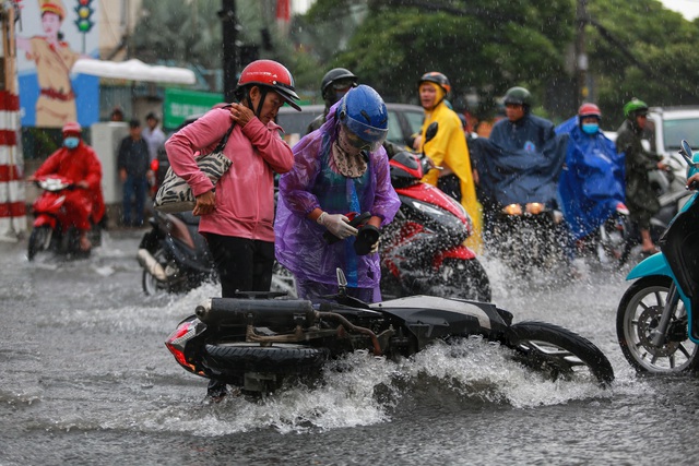  [ẢNH] Nước chảy xiết kéo nhiều xe máy đổ nhào giữa phố Sài Gòn, người dân dắt bộ cho an toàn - Ảnh 6.