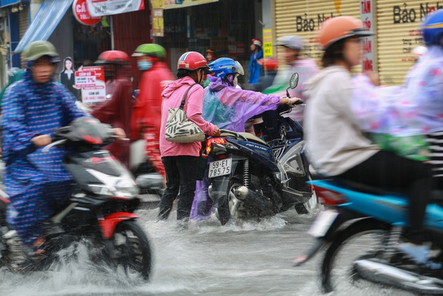  [ẢNH] Nước chảy xiết kéo nhiều xe máy đổ nhào giữa phố Sài Gòn, người dân dắt bộ cho an toàn - Ảnh 7.
