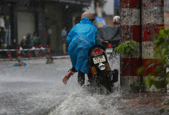  [ẢNH] Nước chảy xiết kéo nhiều xe máy đổ nhào giữa phố Sài Gòn, người dân dắt bộ cho an toàn - Ảnh 9.