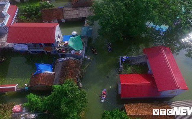 Video Flycam: Nước ngập đầu người, dân Thủ đô đi lại trên mái nhà lấy đồ cứu trợ