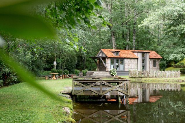 Ngôi nhà nhỏ tuyệt đẹp nằm nép mình giữa hồ nước và rừng cây. Lối vào nhà là một thảm cỏ xanh mướt chạy dài. 